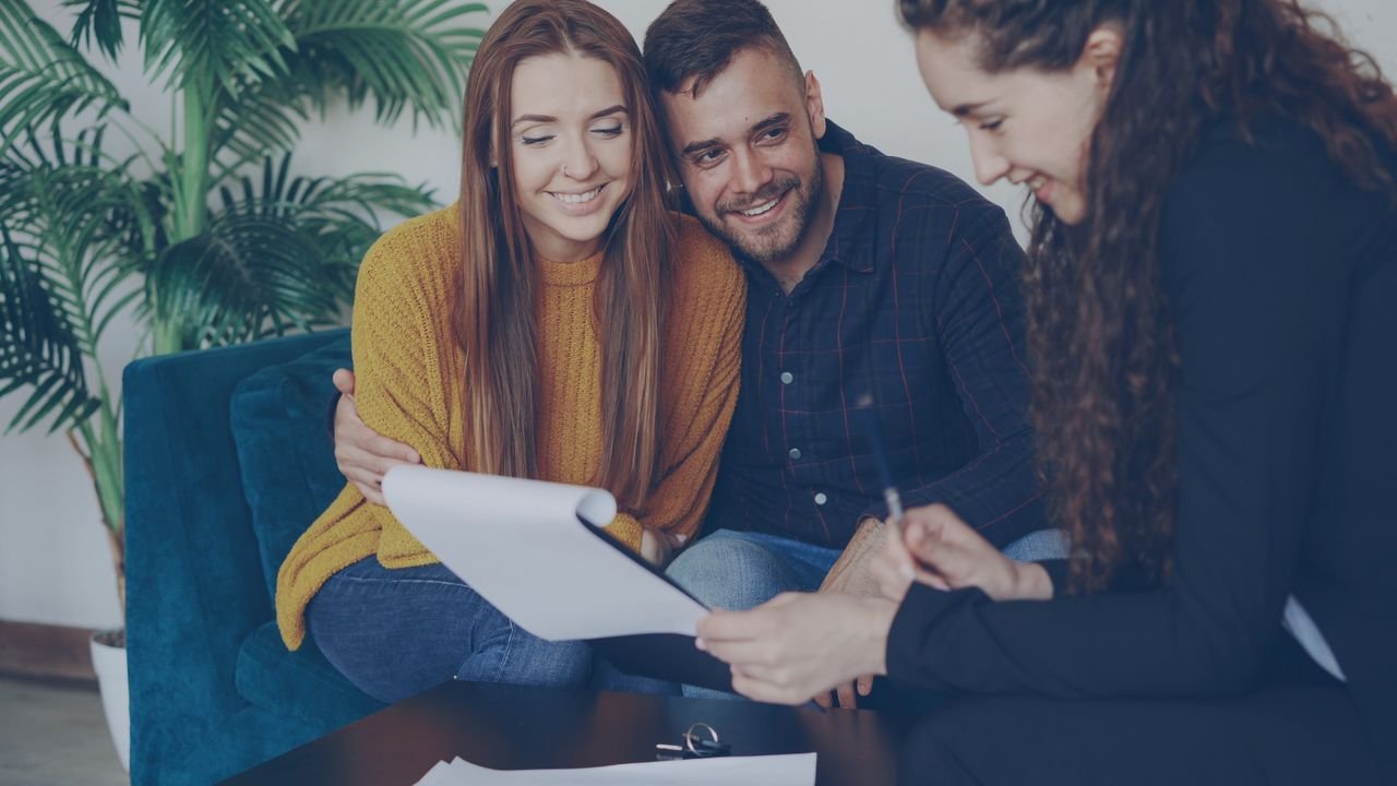 Services Happy couple discussing finance with advisor in cozy office setting.