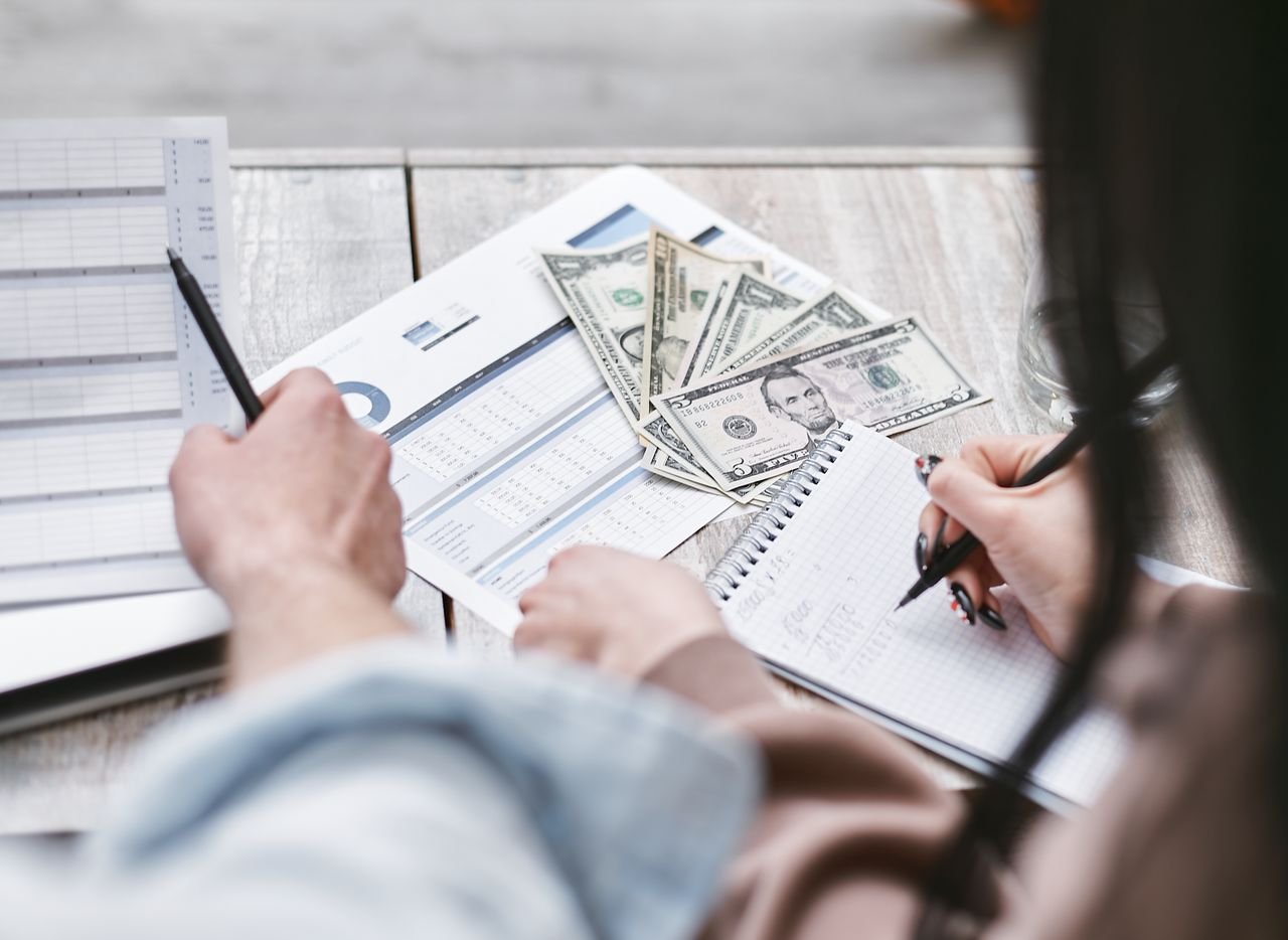 Mastering the First Impression: Your intriguing post title goes here Two people working on financial documents and dollar bills for budgeting.