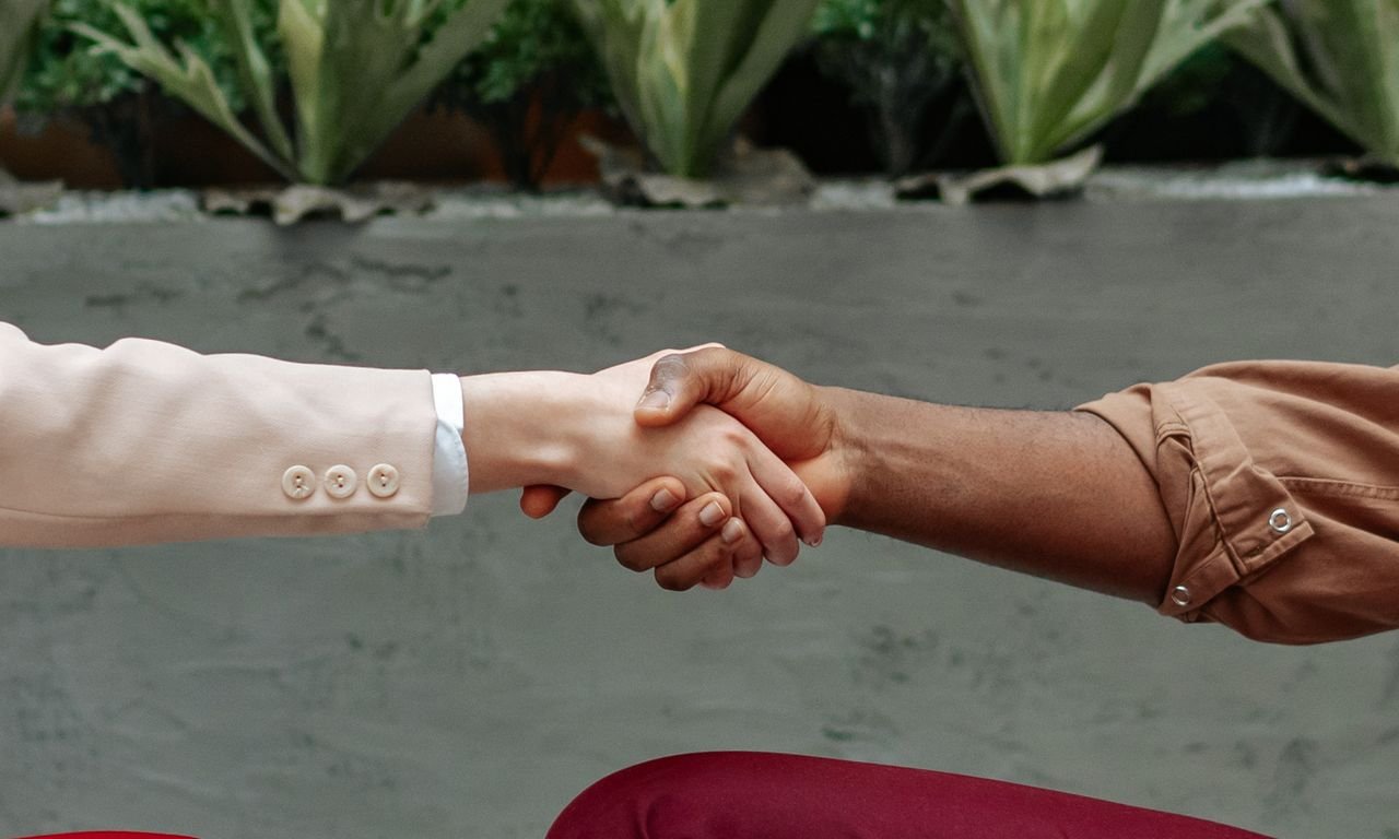 Services Close-up of diverse hands shaking indoors, symbolizing partnership and agreement.