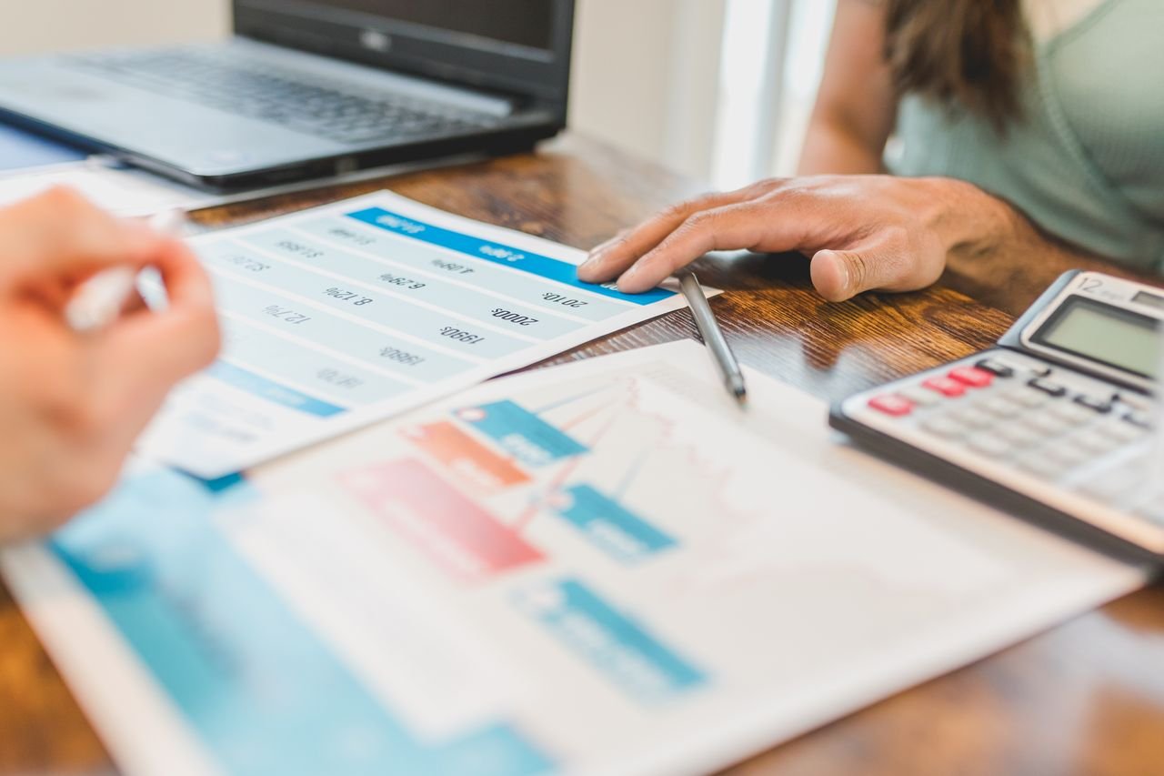 The Art of Drawing Readers In: Your attractive post title goes here Hands at a desk with financial graphs, calculator, and pen, analyzing business data.